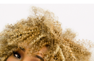 A head of hair in ringlets colored blonde.